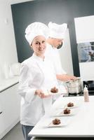 Cheerful young woman pâtissier professionnel au travail photo