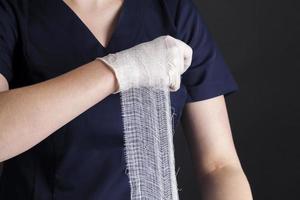 bandage blanc médical entre les mains d'une femme médecin photo