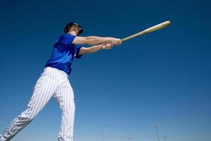 pâte de baseball, en uniforme bleu, frapper la balle pendant la compétition