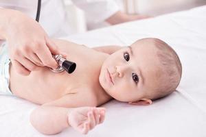 le médecin examine bébé avec stéthoscope photo