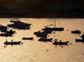 rétro-éclairage de bateaux de sport au mouillage dans une baie photo