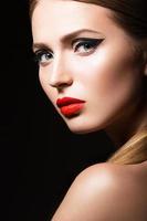 belle fille avec des flèches noires inhabituelles et des lèvres rouges. photo