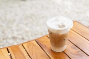 mise au point sélective, café frais, cappuccino glacé, macchiato, latte avec lait et café séparés. café dans une tasse en plastique sur une table en bois. Tasse à café glacée en plastique sur table en bois photo