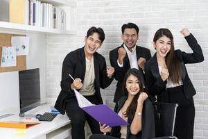 oui les hommes d'affaires triomphent grâce à la croissance financière de l'entreprise. heureux hommes d'affaires souriants triomphant avec les poings levés. photo