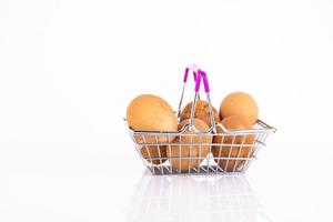 Oeufs de poule beiges et sauvages dans le panier d'un client sur fond blanc. mise au point sélective. espace de copie. photo