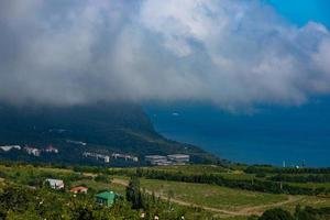 mont ayu dag avec des nuages sur le fond de la mer noire tôt le matin. photo