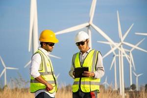 équipe d'ingénieurs travaillant dans une ferme éolienne. énergie renouvelable avec éolienne par concept d'énergie alternative. photo