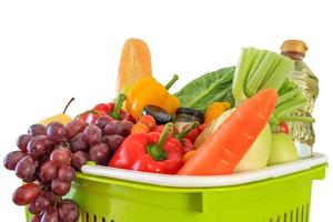 Produits d'épicerie de fruits et légumes frais dans le panier vert isolé sur fond blanc photo