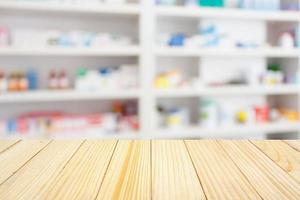 Table de comptoir de pharmacie de pharmacie avec fond abstrait flou avec des médicaments et des produits de santé sur des étagères photo