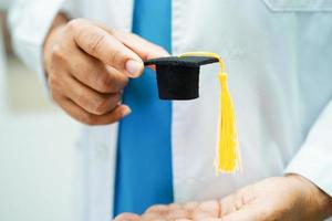 femme médecin asiatique tenant un chapeau de graduation à l'hôpital, concept d'éducation médicale. photo