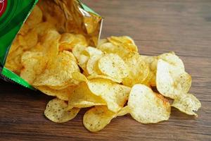 croustilles dans un sac ouvert, délicieux assaisonnement pour barbecue épicé pour les frites, collation frite en tranches fines restauration rapide dans un sac ouvert. photo