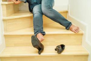 femme d'affaires asiatique douleur à la cheville, pied avec crampe à la jambe et chute dans les escaliers à cause des surfaces glissantes au bureau. photo