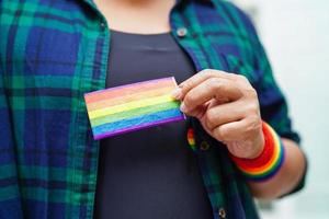 femme asiatique avec drapeau arc-en-ciel, droits des symboles lgbt et égalité des sexes, mois de la fierté lgbt en juin. photo