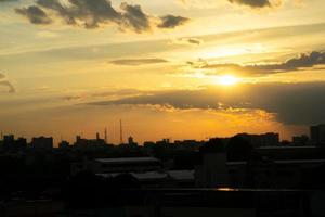 donne une sensation de chaleur, coucher de soleil derrière le bâtiment de la ville, silhouette des grands bâtiments de la ville, silhouette du bâtiment à nouveau beau fond de ciel et concept de liberté. photo