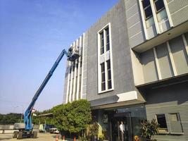 grue élévatrice avec plate-forme de levage sur le toit d'un bâtiment photo