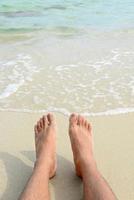 homme pieds nus se détendre sur la plage. photo