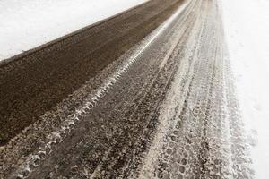 neige fondue sur la route goudronnée en gros plan photo