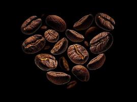 grains de café en forme de coeur sur fond noir photo