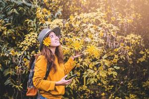 photos en gros plan de jeunes femmes heureuses se détendant en appréciant la beauté bua tong fleur jaune tournesol mexicain tung bua tong à maehongson