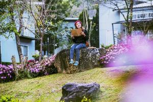 femme voyage nature dans le jardin fleuri. détendez-vous assis sur des rochers et lisez des livres au milieu de la nature à doi inthanon. photo