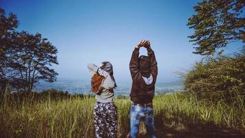 les couples voyagent nature. voyage se détendre. gazon naturel debout sur la montagne. voyage de noces couple heureux. photo