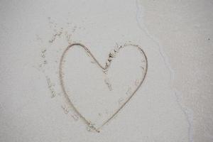 coeurs dessinés sur le sable d'une plage photo