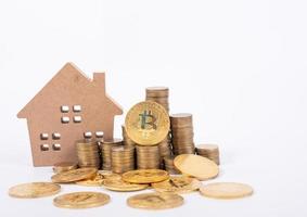 achat et vente de biens immobiliers pour le concept de bitcoins avec petite maison de campagne et pièce de monnaie en métal doré. photo