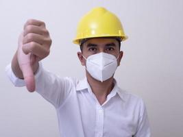 les travailleurs industriels asiatiques portent des casques jaunes, portent des masques de protection pour leur santé photo