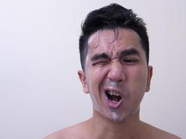 les hommes asiatiques se lavent le visage avec de la mousse, le concept de soins de la peau des hommes photo