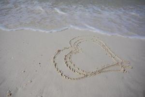 coeurs dessinés sur le sable d'une plage photo