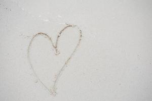 coeurs dessinés sur le sable d'une plage photo