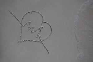 coeurs dessinés sur le sable d'une plage photo