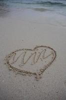 coeurs dessinés sur le sable d'une plage photo