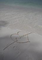 coeurs dessinés sur le sable d'une plage photo