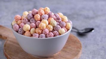 mélange de boules de céréales de maïs colorées, bonbons de bol de saveur de fruits sur fond de ciment gris, gros plan, petit déjeuner frais, délicieux et sain, concept de design d'espace de copie. photo