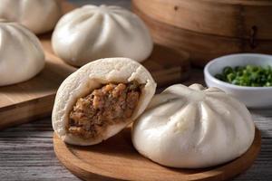 délicieux baozi, pain de viande cuit à la vapeur chinois est prêt à manger sur une assiette de service et un cuiseur à vapeur, gros plan, copiez le concept de conception de produit de l'espace. photo