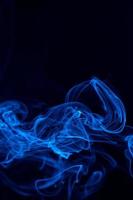 image conceptuelle de fumée de couleur bleue isolée sur fond noir foncé, concept d'élément de conception d'halloween. photo