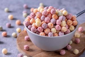 mélange de boules de céréales de maïs colorées, bonbons de bol de saveur de fruits sur fond de ciment gris, gros plan, petit déjeuner frais, délicieux et sain, concept de design d'espace de copie. photo