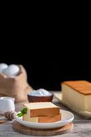 castella kasutera - délicieux gâteau éponge japonais en tranches sur une assiette blanche sur une table en bois rustique, gros plan, alimentation saine, conception d'espace de copie. photo