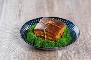 Viande de porc dong po rou dongpo dans une belle assiette bleue avec des légumes de brocoli vert, nourriture festive traditionnelle pour le repas de cuisine du nouvel an chinois, gros plan. photo