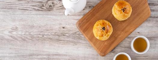 gâteau de lune jaune d'oeuf, gâteau de lune pour les vacances du festival de la mi-automne, concept de conception de vue de dessus sur une table en bois clair avec espace de copie, pose à plat, prise de vue aérienne photo