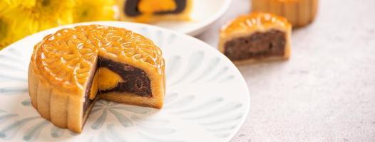 délicieux gâteau de lune de pâtisserie au jaune d'oeuf cuit au four pour le festival de la mi-automne sur fond de table en ciment brillant. concept de cuisine traditionnelle chinoise, gros plan, espace de copie. photo