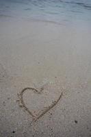 coeurs dessinés sur le sable d'une plage photo