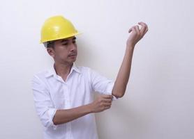 ingénieur avec les mains croisées portant un casque jaune sur fond blanc photo