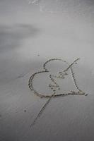 coeurs dessinés sur le sable d'une plage photo