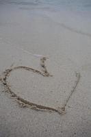 coeurs dessinés sur le sable d'une plage photo