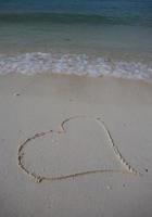 coeurs dessinés sur le sable d'une plage photo