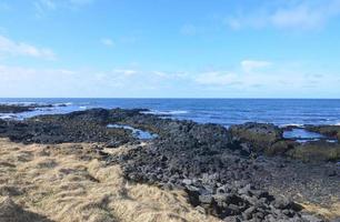 paysage marin du littoral avec océan bleu et roche de lave photo