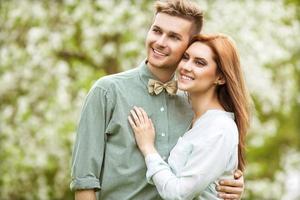 couple amoureux dans parc souriant tenant un bouquet photo