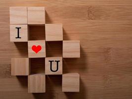 mot amour sur des cubes en bois avec coeur rouge, gros plan près de fond blanc concept de la Saint-Valentin photo
